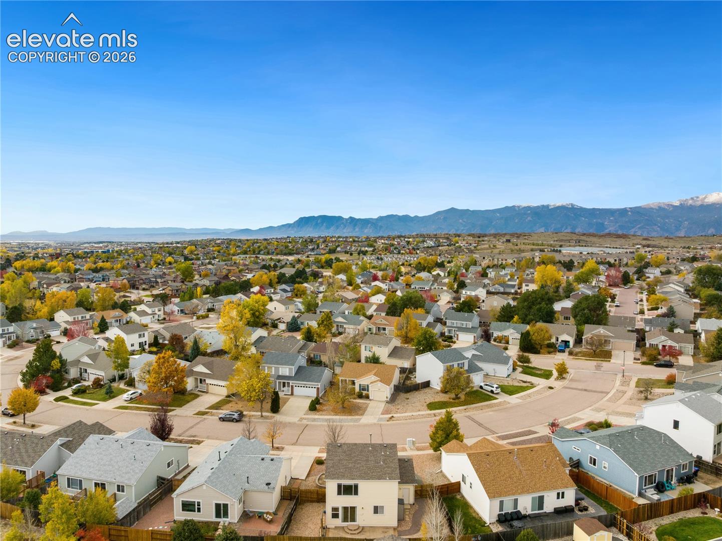 Aerial perspective featuring established residential streets, mature landscaping, and mountain backdrops