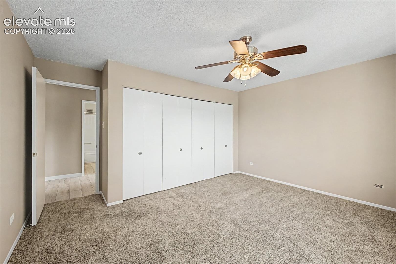 Spacious room featuring neutral carpeting and light beige wall paint