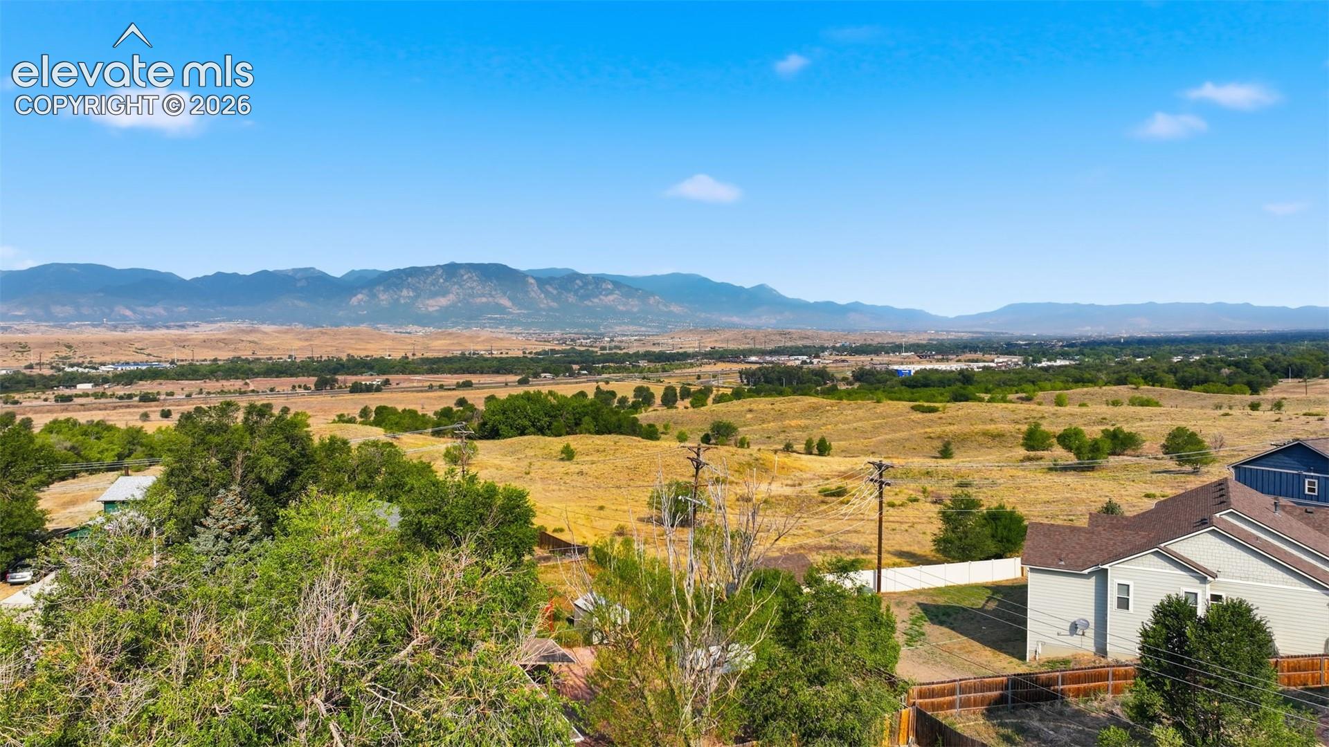 Expansive landscape featuring distant mountains and open fields