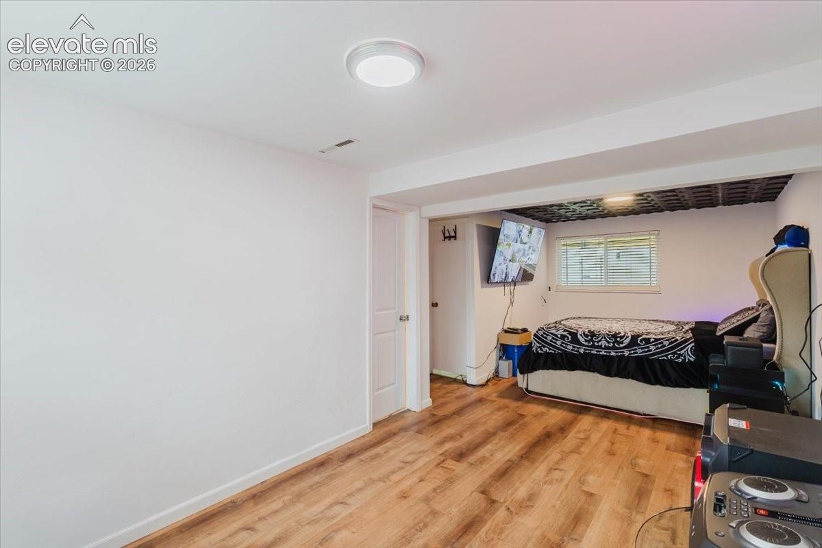 Interior space featuring wood-finish flooring, white walls, and a white ceiling with a flush-mount light fixture