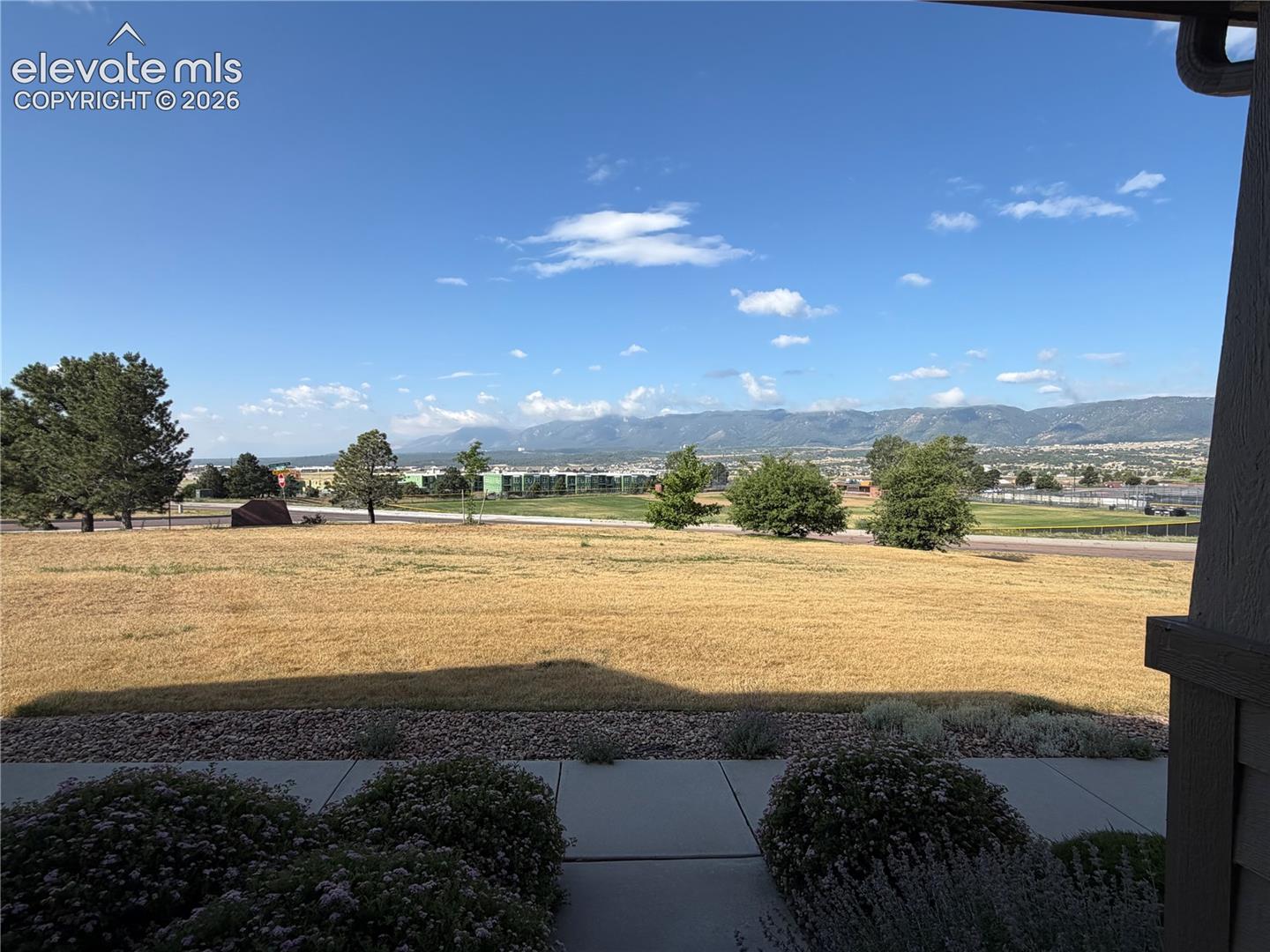 Expansive outdoor area featuring a wide expanse of terrain, distant mountains, and established trees