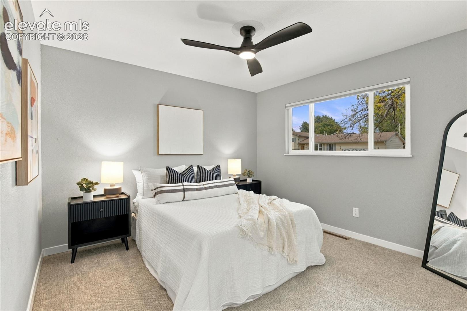 Neutral wall tones, wall-to-wall carpeting, and a modern ceiling fan with integrated lighting