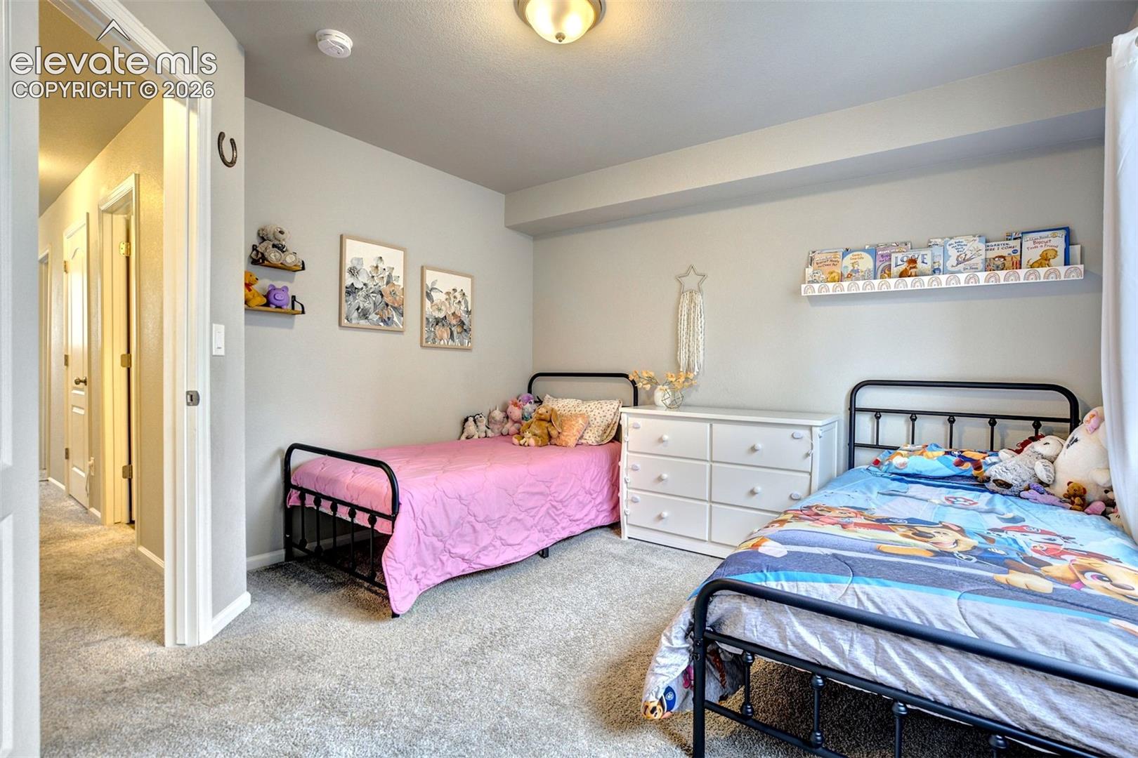 Room featuring neutral-toned carpeting, flush-mount ceiling lighting, and built-in floating shelving