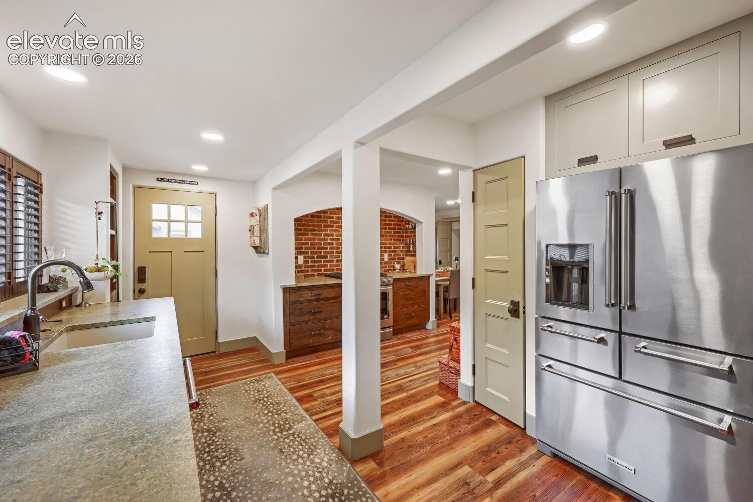 Kitchen featuring wood-finish flooring, recessed lighting, and a stainless steel refrigerator