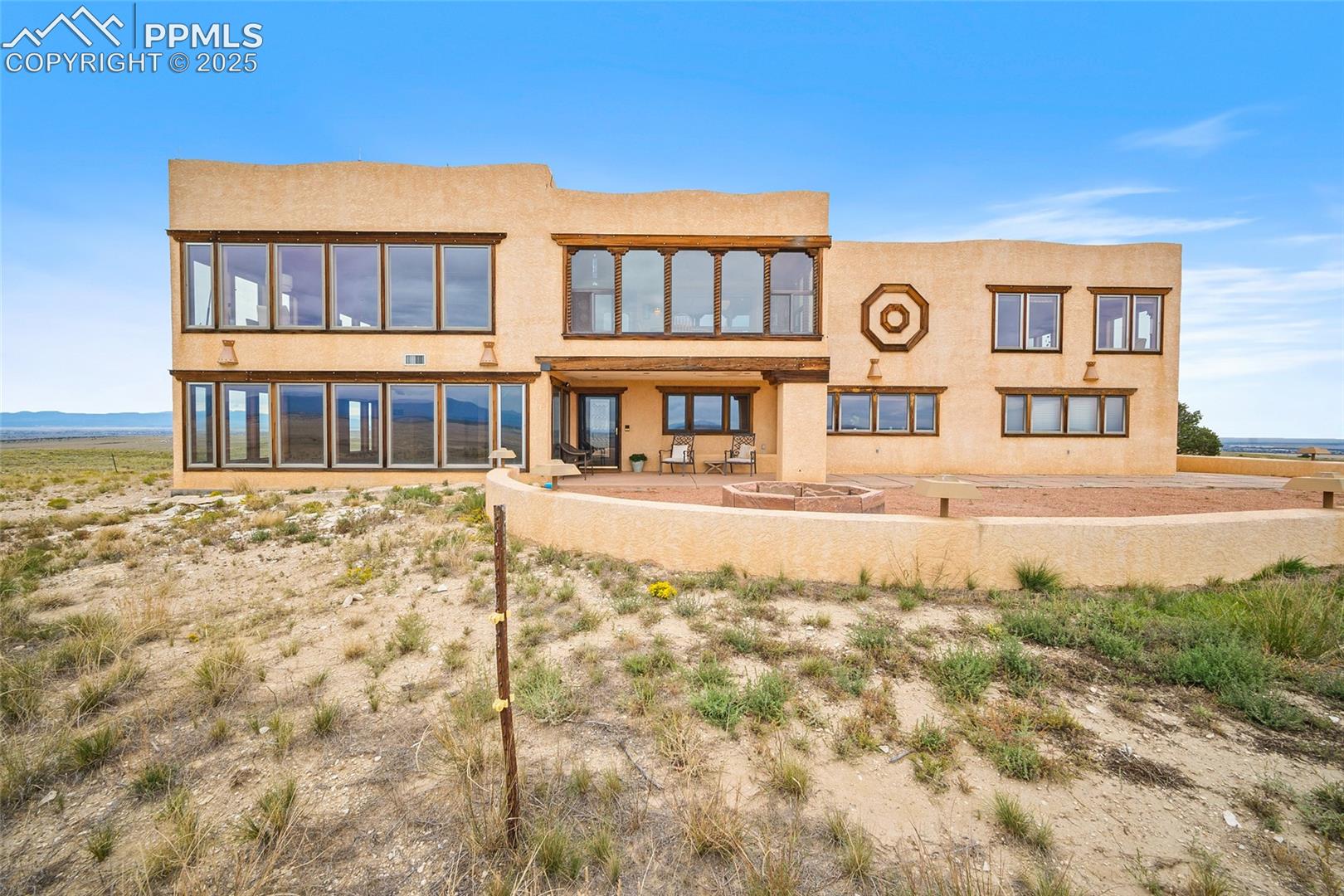 Rear view of house with stucco siding and a patio