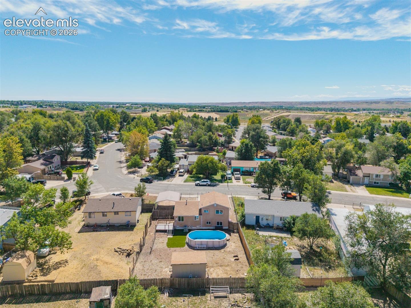 Spacious lot featuring a detached carport, fenced yard, and an above-ground pool on a quiet street conveniently located near Ft. Carson. 