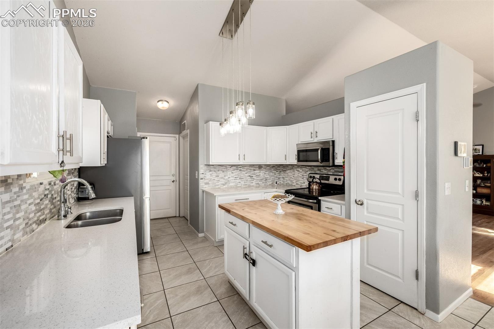 Updated Kitchen with beautiful white cabinetry and quartz/butcher block countertops