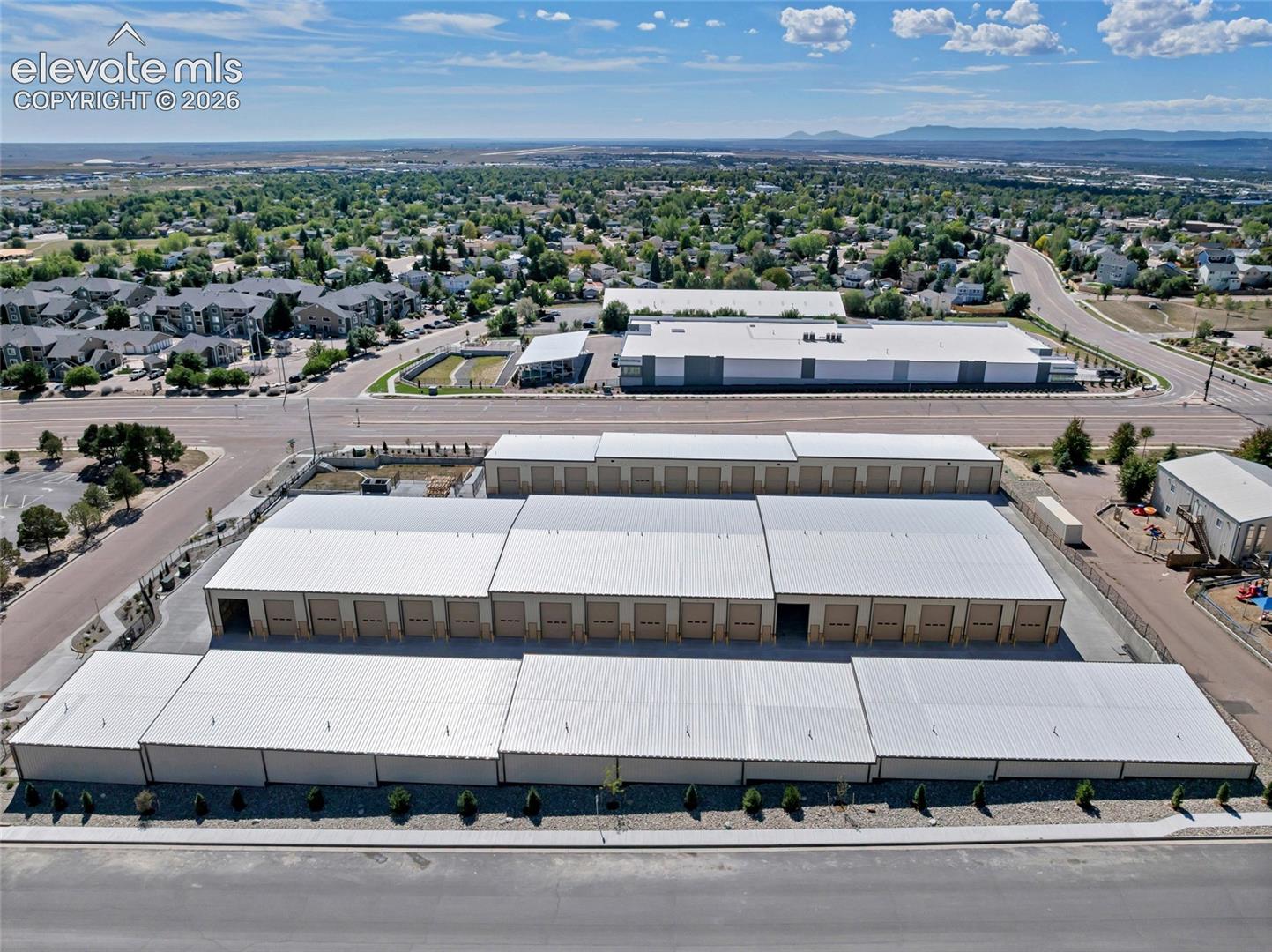Multiple storage buildings with metal roofs and roll-up doors