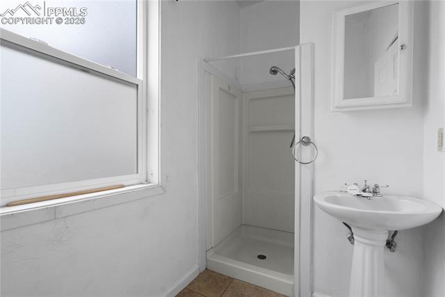 Full bathroom with a shower stall and light tile patterned floors