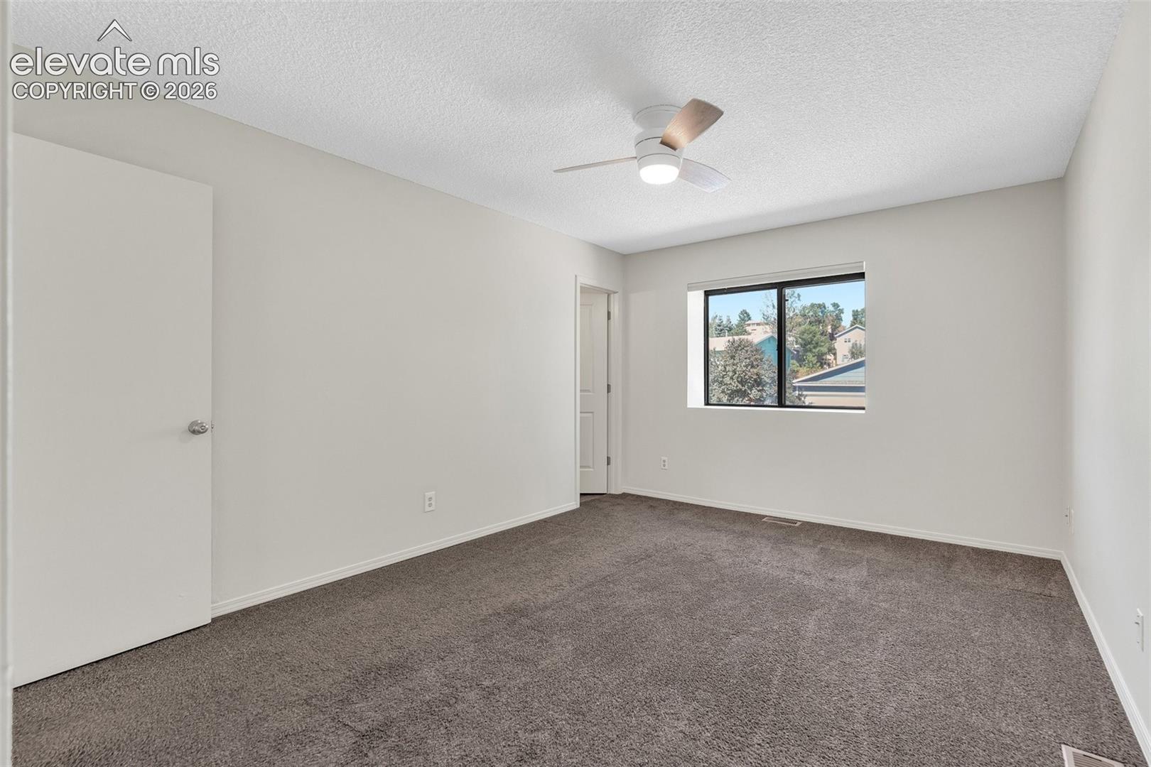 Neutral-toned walls complement the dark gray carpeting