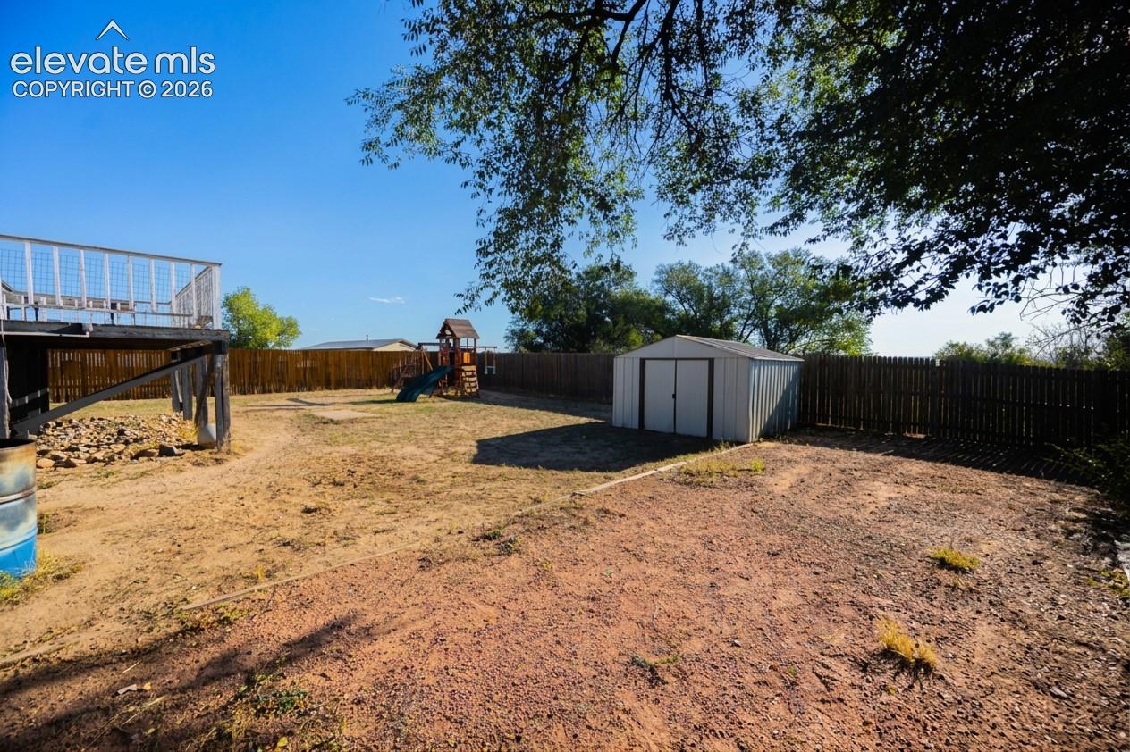 Expansive backyard with a wood privacy fence and a metal storage shed