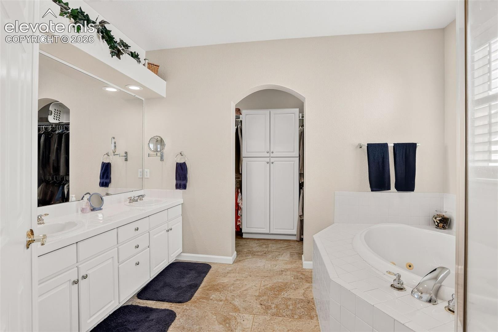 Dual vanity with undermount sinks, an expansive mirror, and recessed lighting