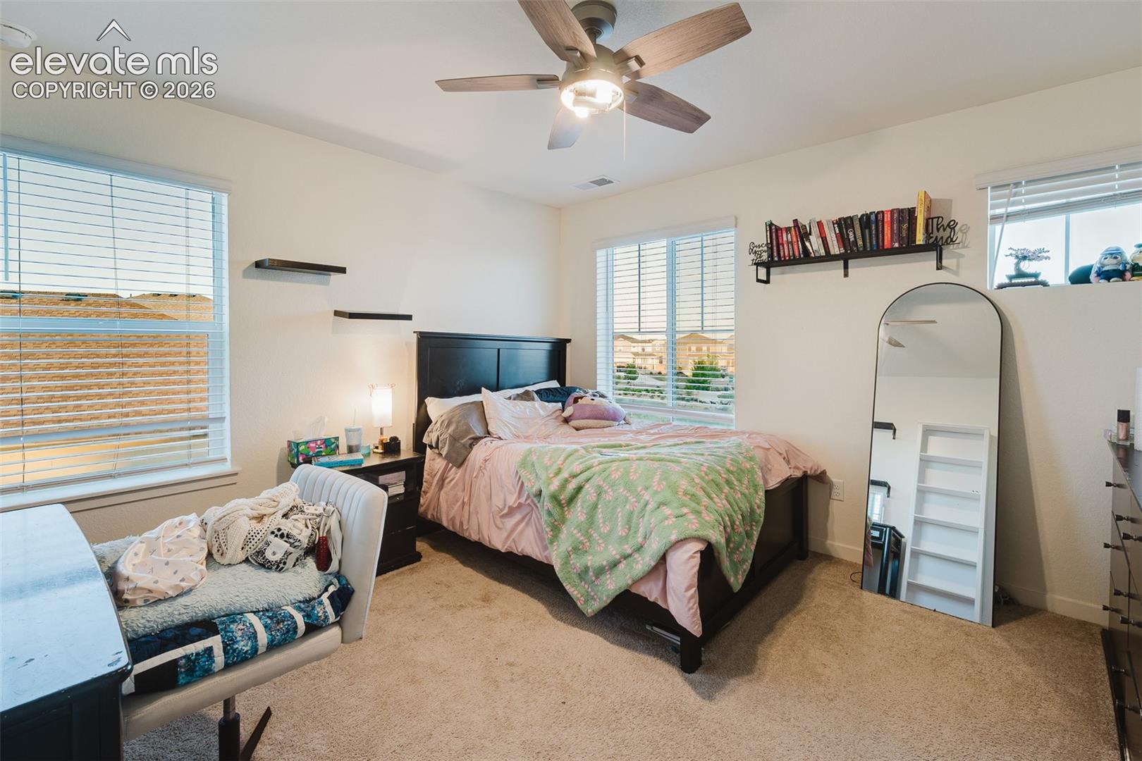 Upper Level Bedroom #5 with lighted ceiling fan and neutral carpet.