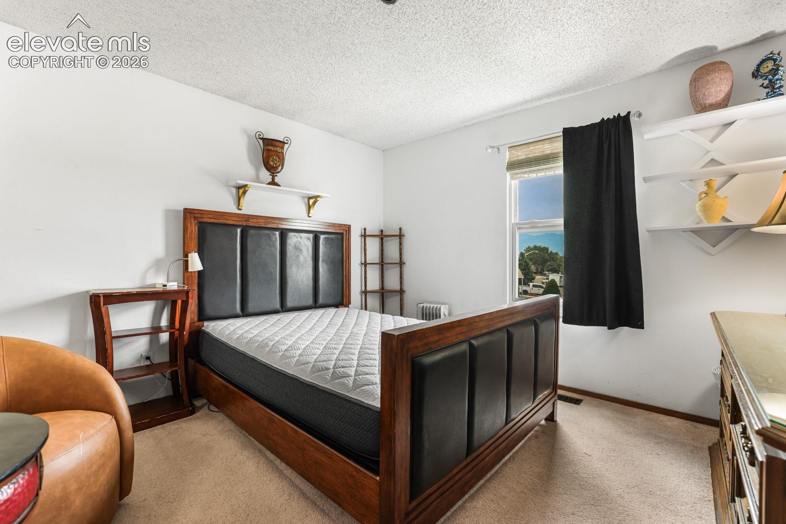 Bedroom featuring carpet flooring, white walls, and a window with blinds