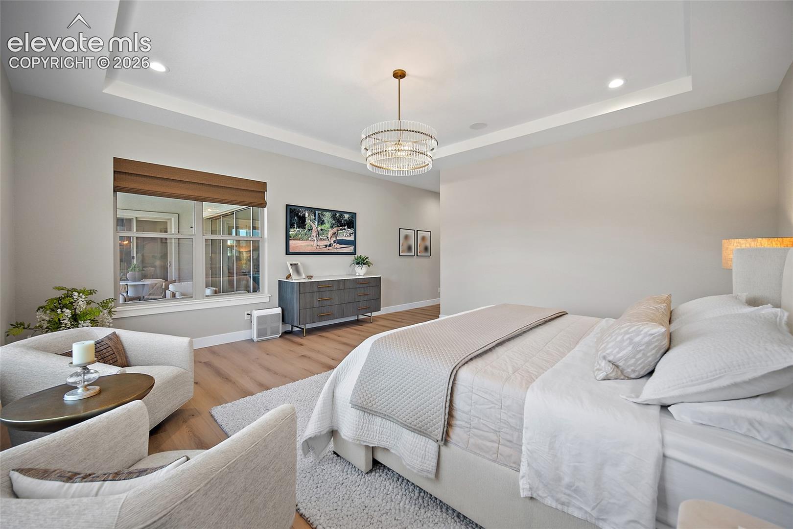 Tray ceiling with recessed lighting and a decorative chandelier
