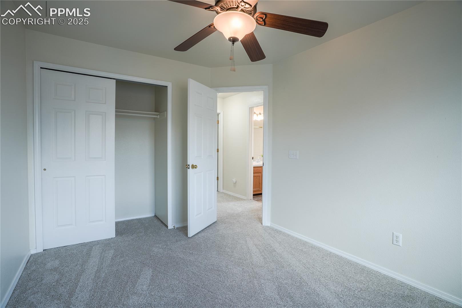 Unfurnished bedroom featuring carpet floors, a ceiling fan, and a closet