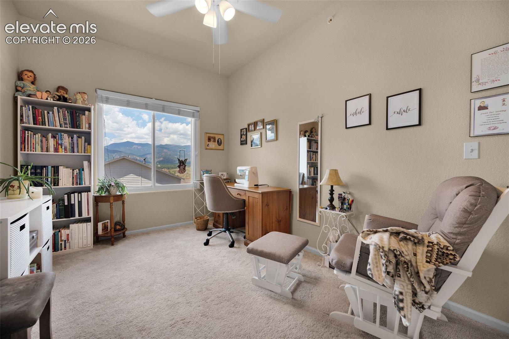 Large bedroom #2 being used as a study. Carpeted with a vaulted ceiling and a ceiling fan with integrated lighting. Note the terrific view of the mountains.
