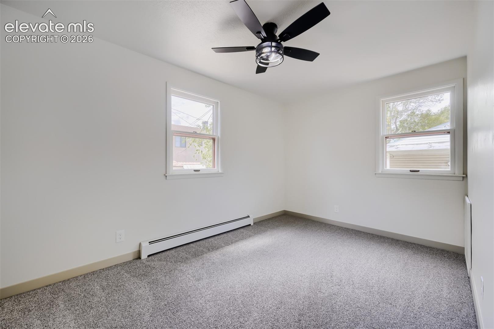 Neutral carpet flooring, white walls, and a black ceiling fan with integrated lighting