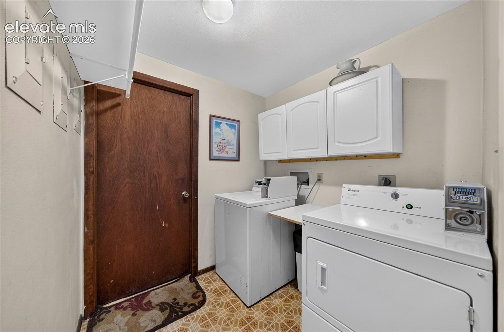 Laundry area featuring white cabinetry, a built-in shelf, and patterned resilient flooring
