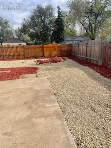 Private backyard with room for RV or boat on gravel drive. Wood fence.