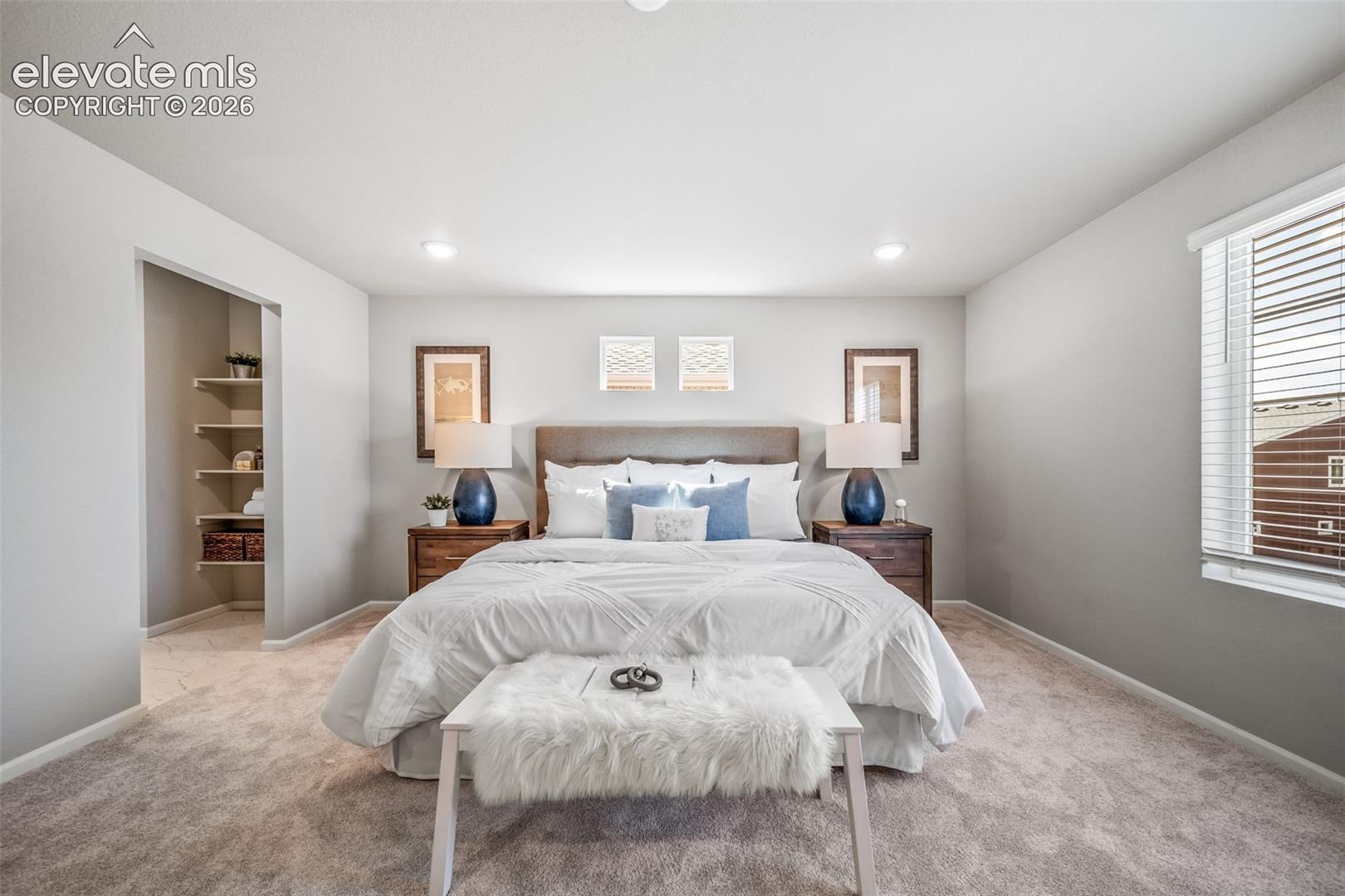 Recessed lighting, light gray wall color, textured carpeting, built-in shelving, and a large window with blinds
*photos of a model home*