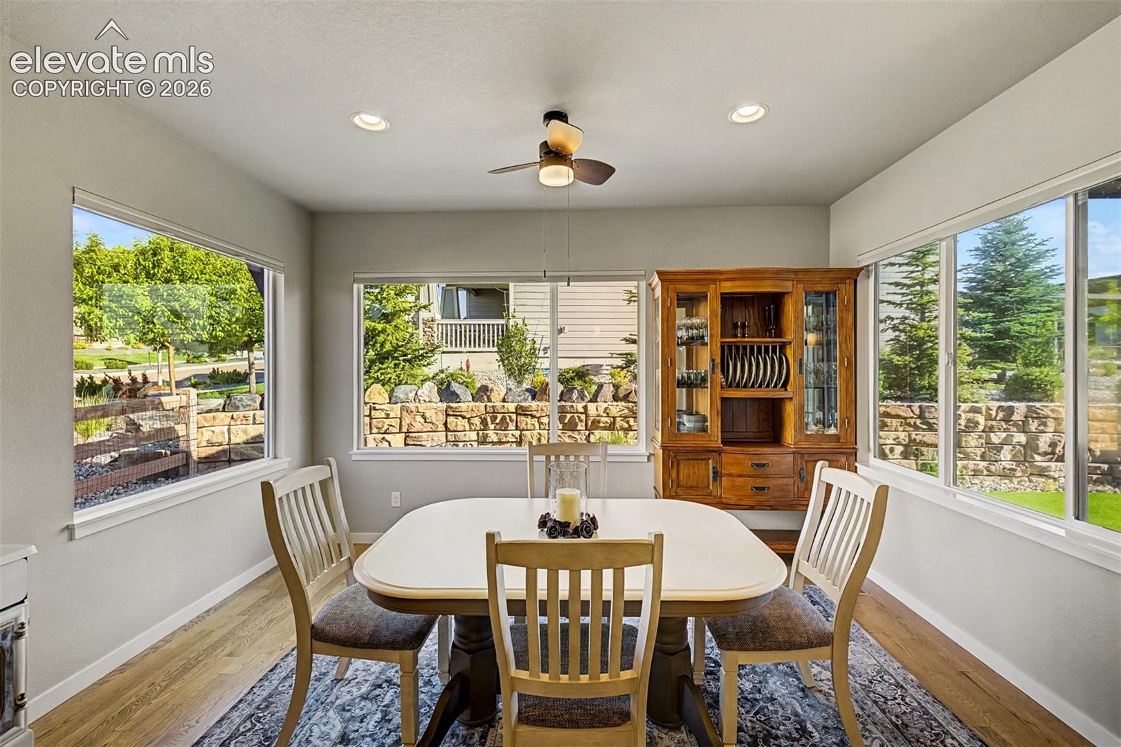 Light-filled dining area framed by expansive windows, creating a bright and inviting space for everyday dining.