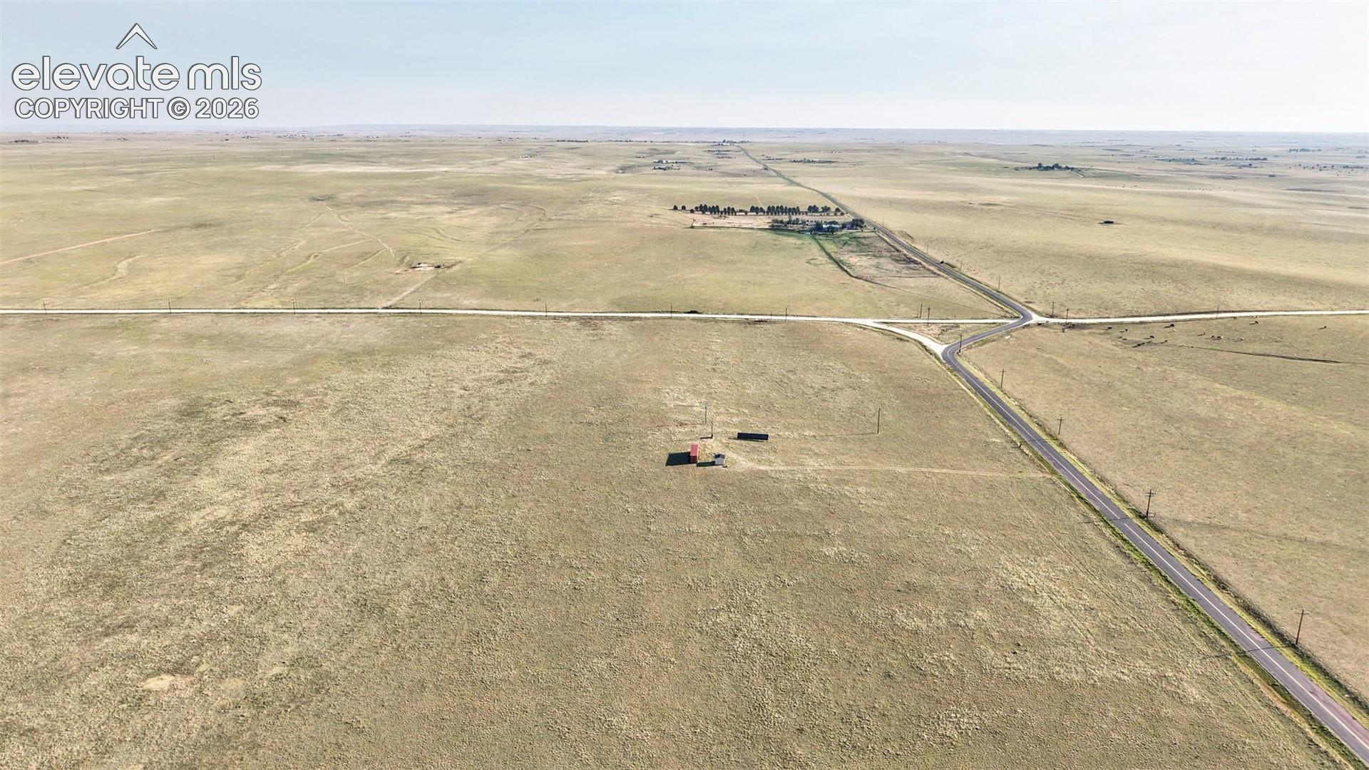 Expansive rural acreage with intersecting roads and distant structures, offering vast open land