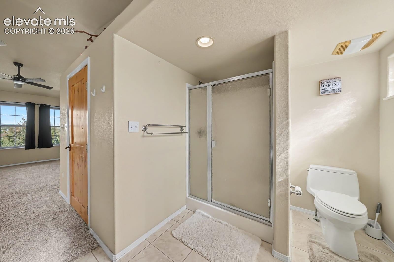 Bathroom featuring a walk-in shower with a glass enclosure, recessed lighting, tile flooring, and a natural wood-finish door