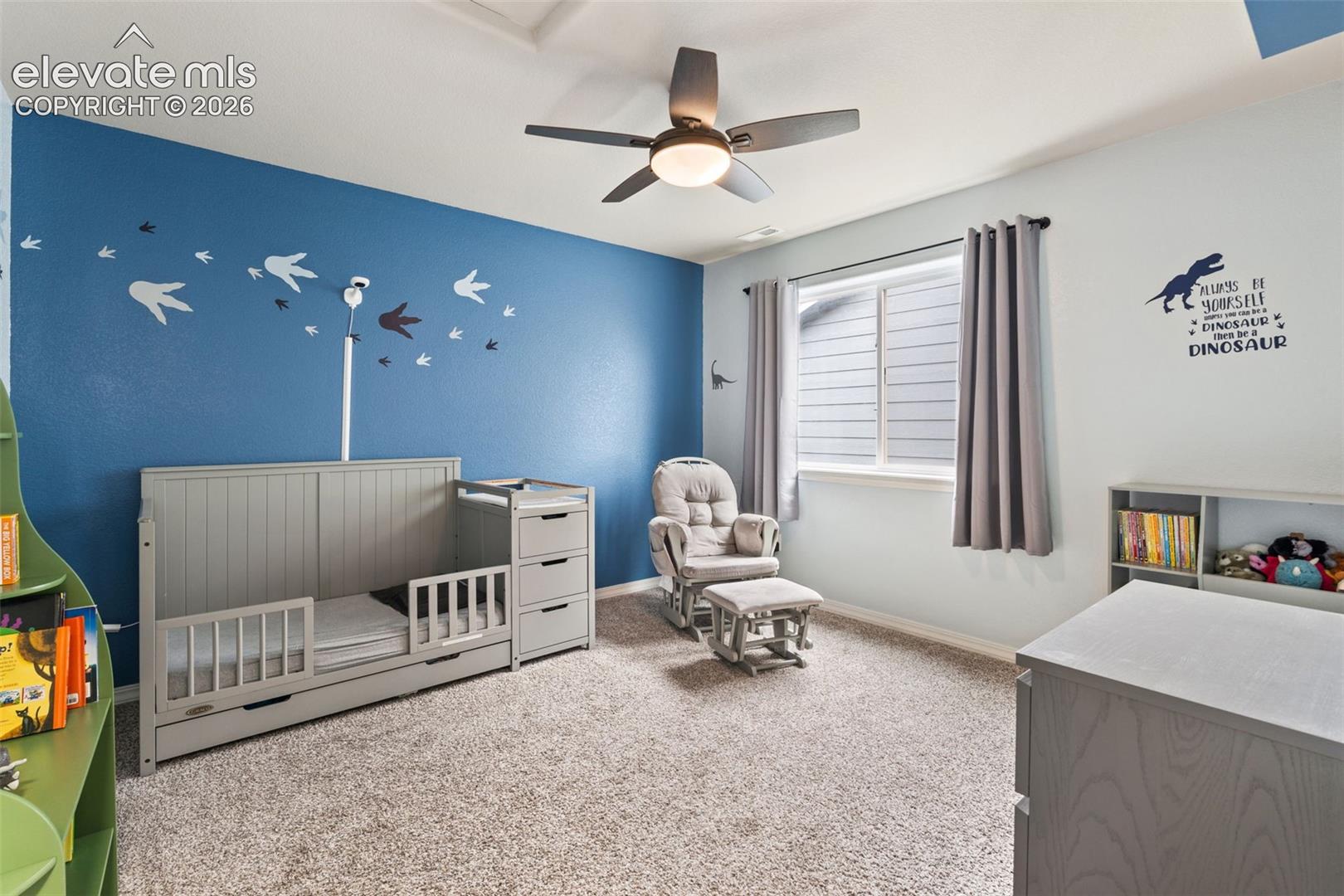 Recessed ceiling, ceiling fan with integrated lighting, natural light from a double-pane window, wall-to-wall carpeting, and painted walls
