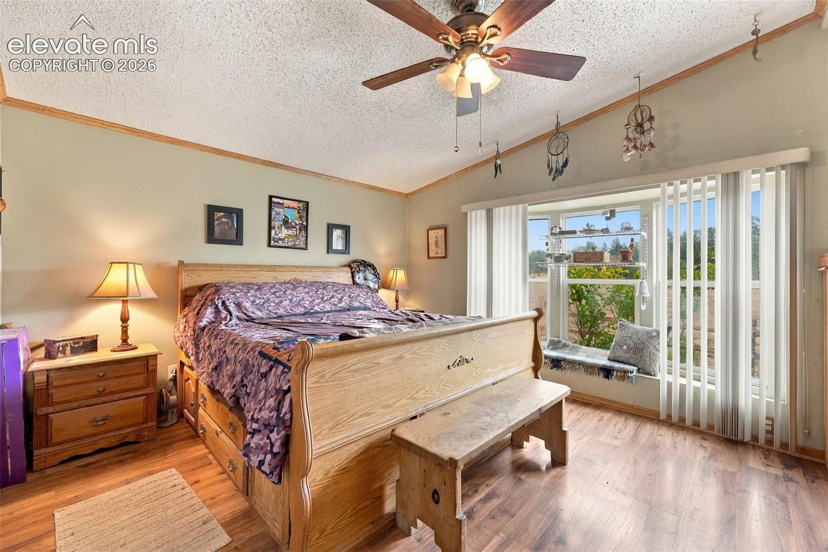 Vaulted ceilings, wood-finish flooring, and bay windows featuring a built-in bench seat