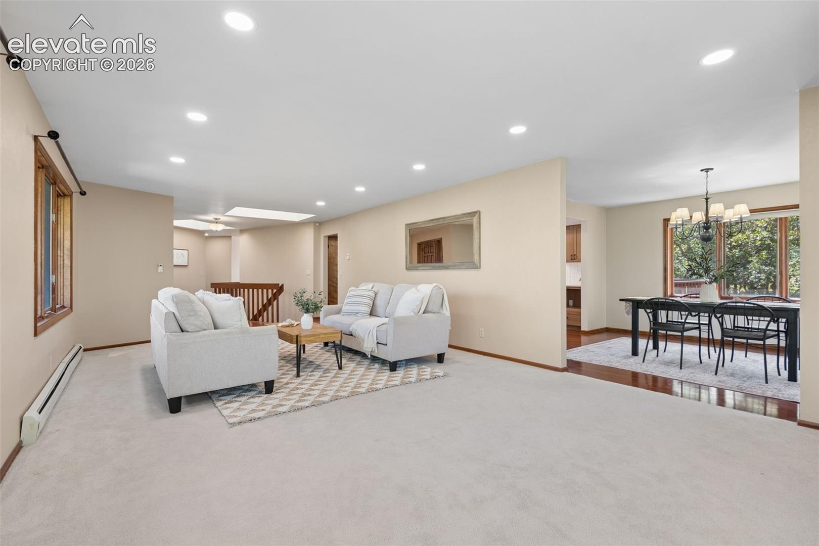Recessed lighting, wood-finish window trim, and a skylight illuminate this living area