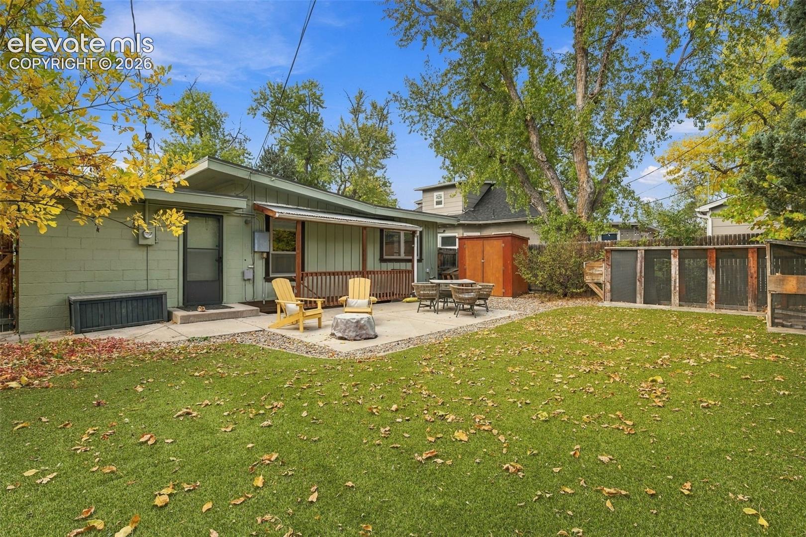 Backyard featuring a concrete patio, wood-deck porch covering, mature trees, and privacy fencing