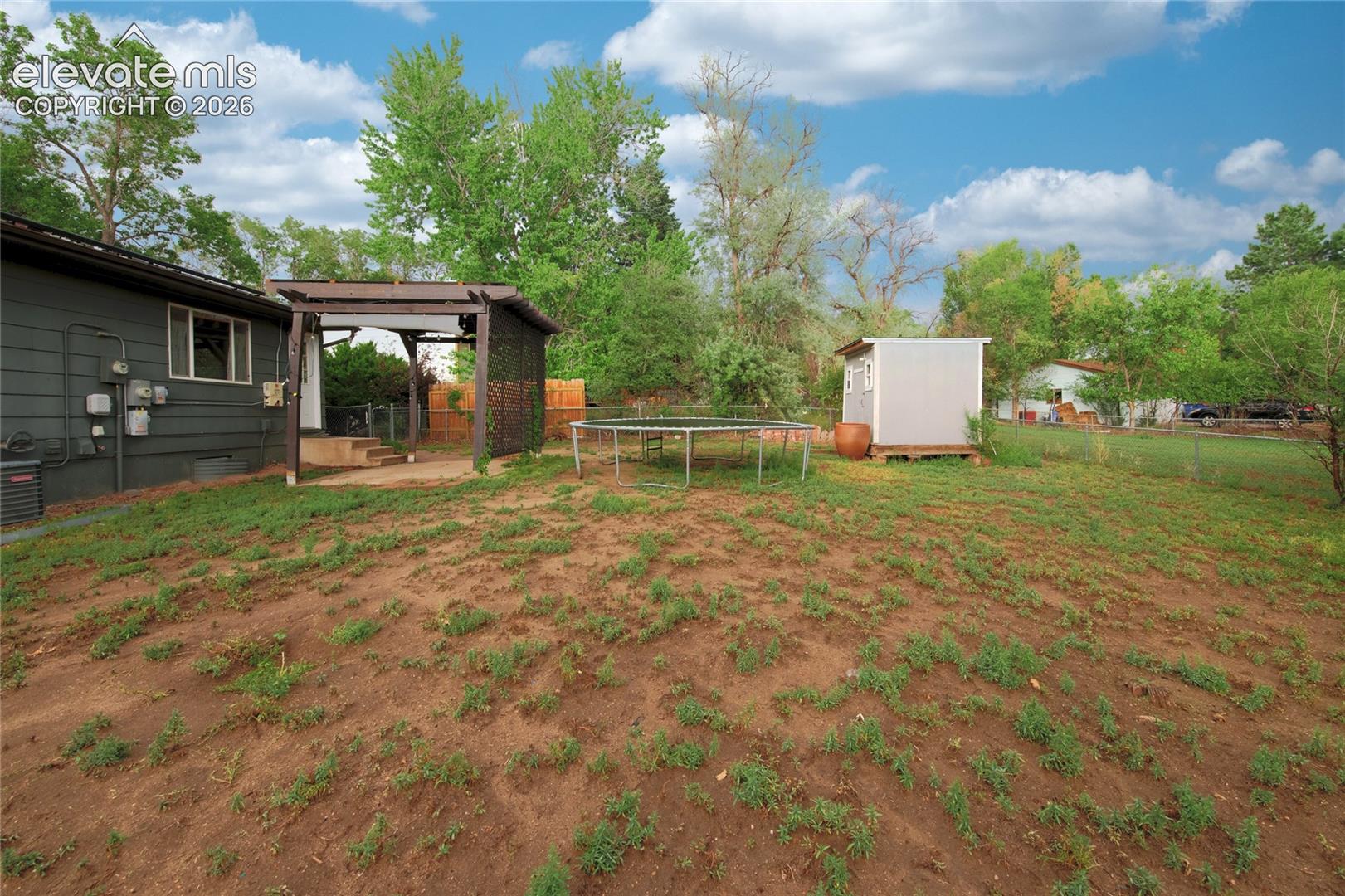 Spacious grounds featuring mature trees, with space for a garden, pets. Includes a modern storage shed