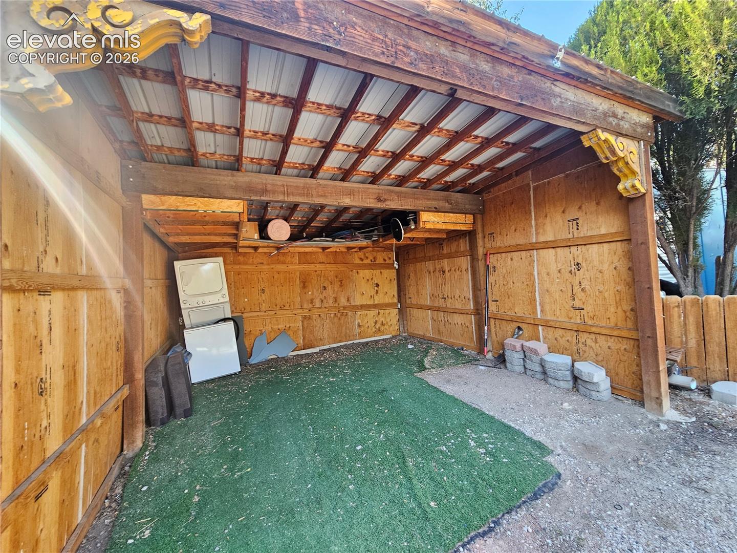 Partially enclosed carport with decorative corbels