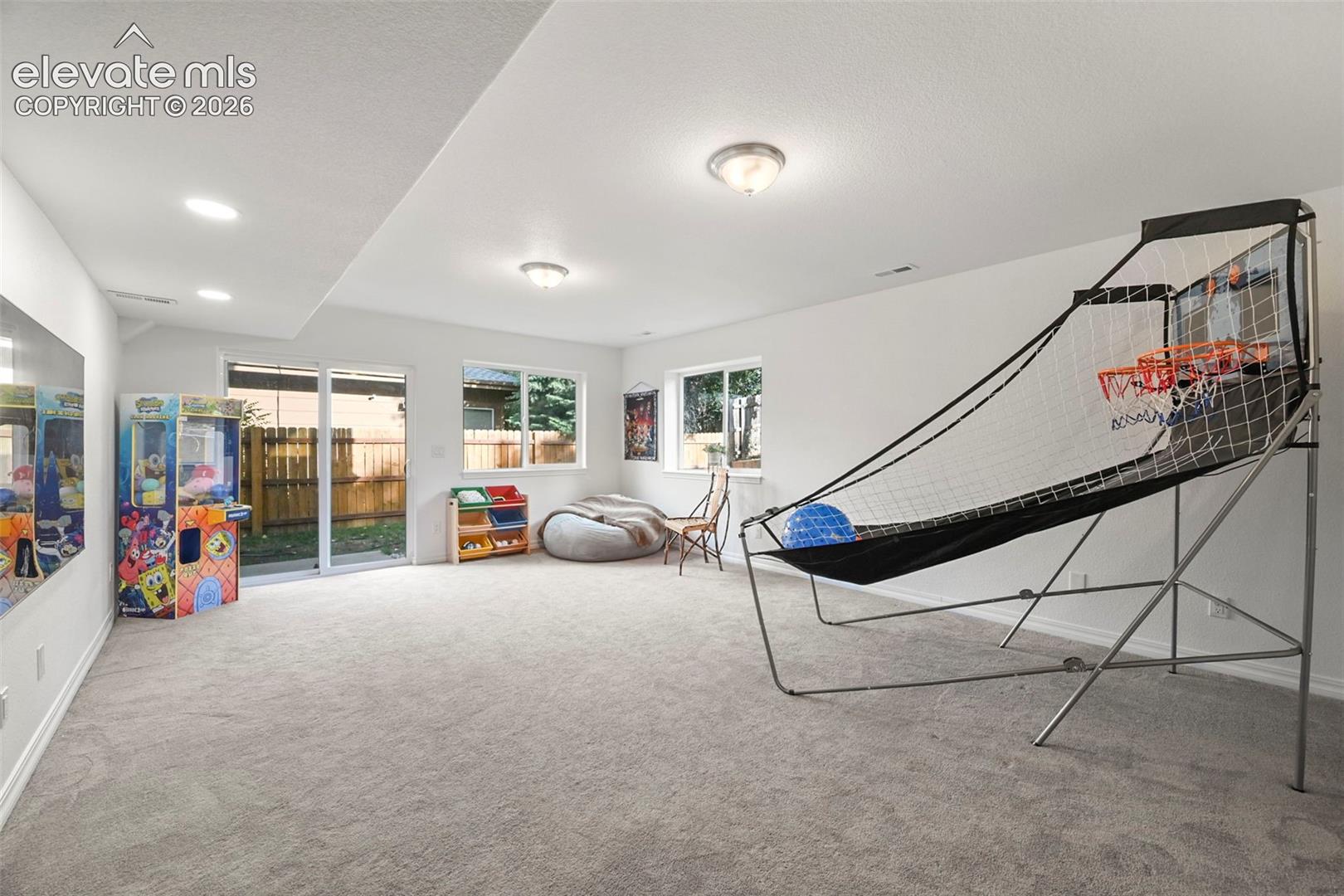 Spacious room featuring carpeted flooring, recessed lighting, and white walls
