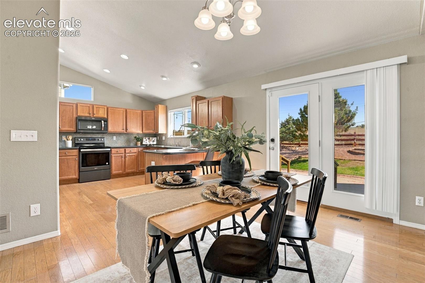 Kitchen with wood-finish flooring, wood cabinetry, and a dark stone-finish countertop