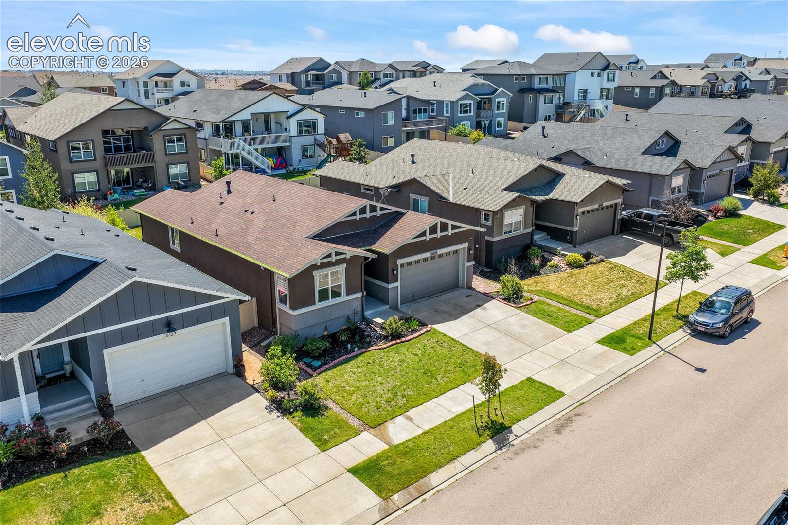 Front aerial view showing landscaping, 2 car garage and neighborhood