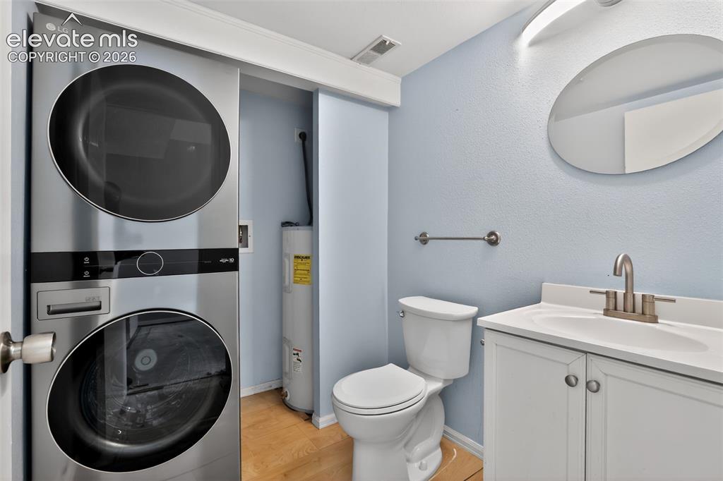 Compact laundry area featuring a stacked washer and dryer unit within a closet