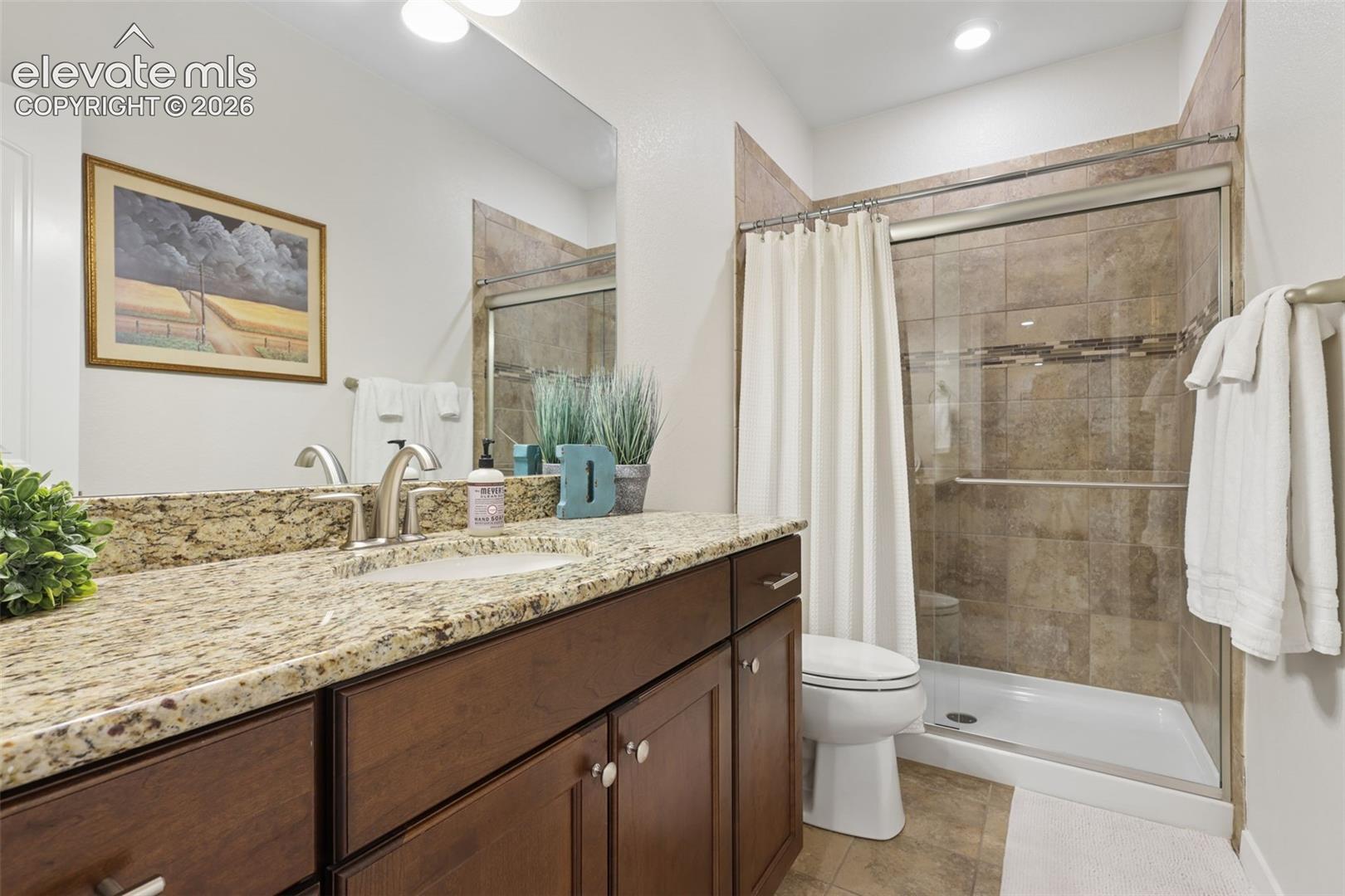 Extended vanity with a granite countertop, undermount sink, and brushed nickel fixtures