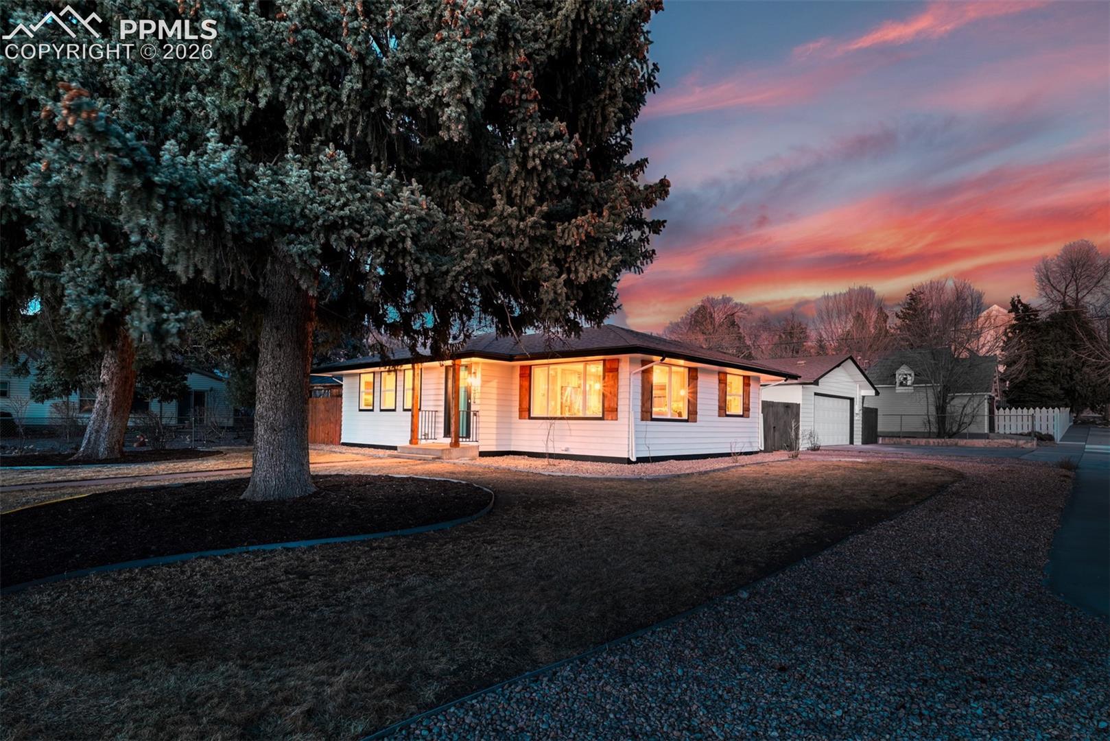 Ranch-style home featuring driveway, a detached garage, and an outbuilding