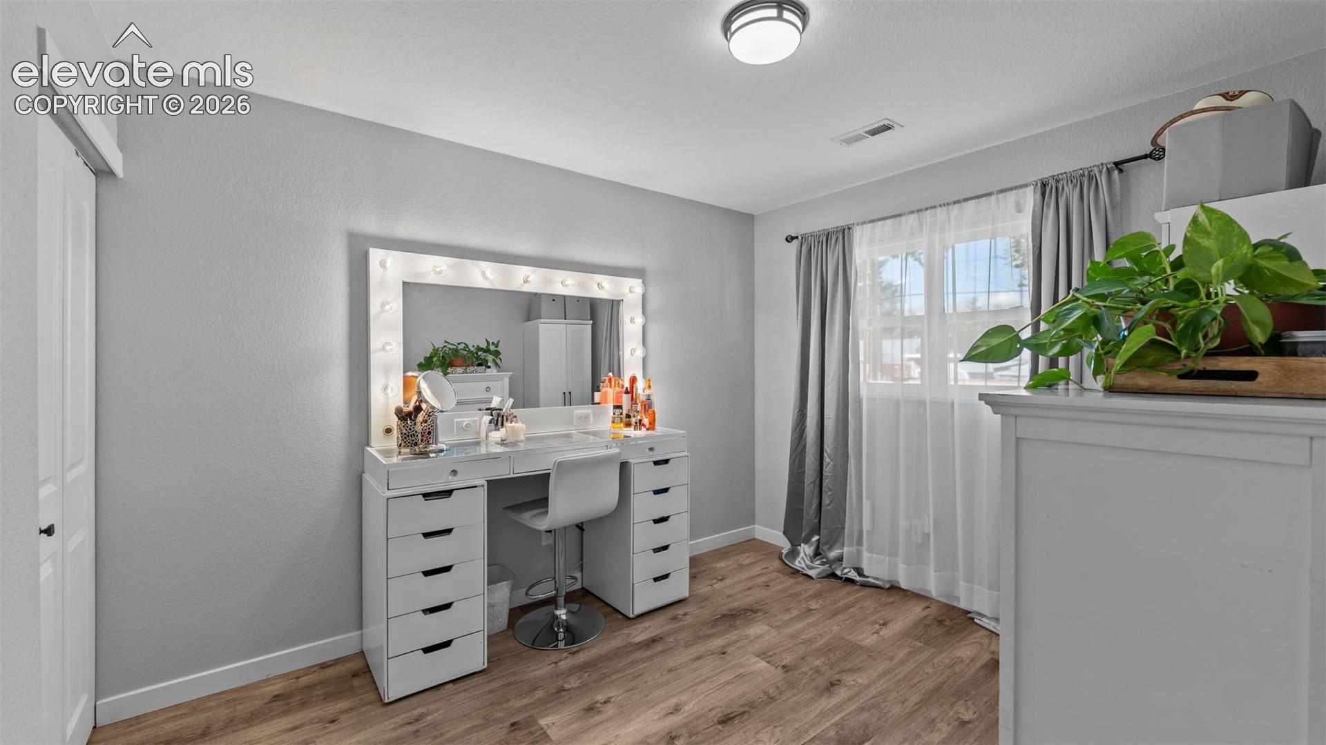 Room featuring wood-finish flooring, a neutral color palette, and a flush-mount ceiling light fixture