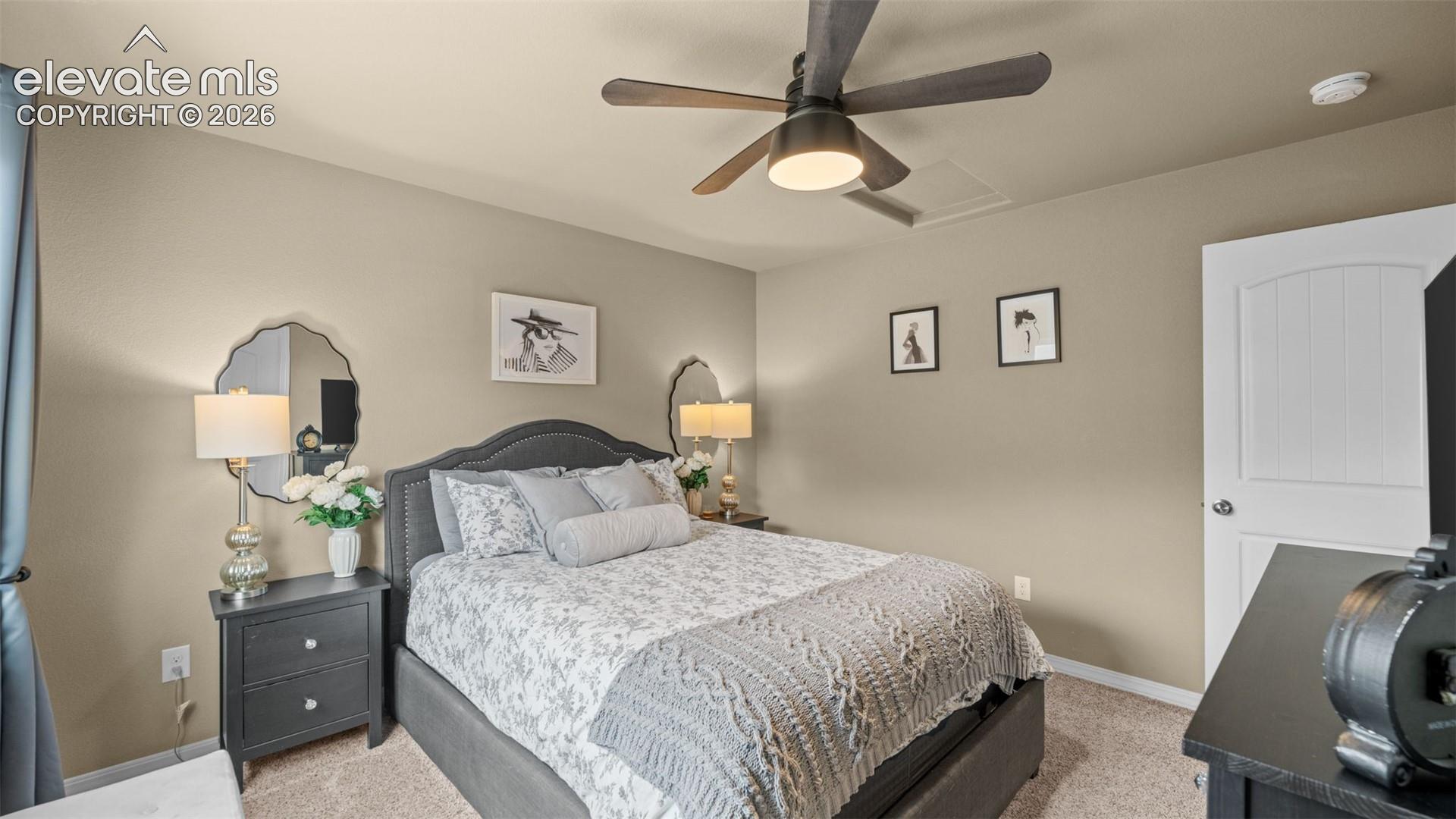 Carpeted room featuring a ceiling fan with integrated lighting, a paneled door, and neutral wall tones