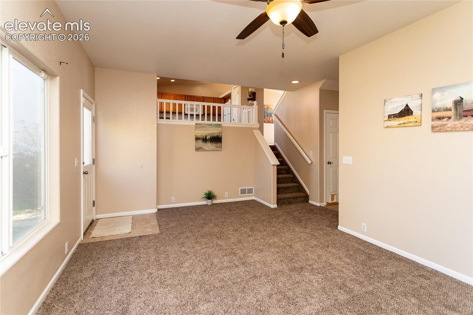 The open family room overlooks the upper floor and steps directly out toward the back patio and yard