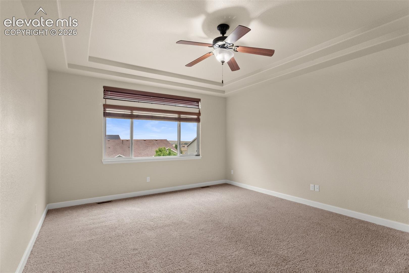 Tray ceiling featuring recessed lighting, carpeted flooring, and a ceiling fan with integrated light fixture