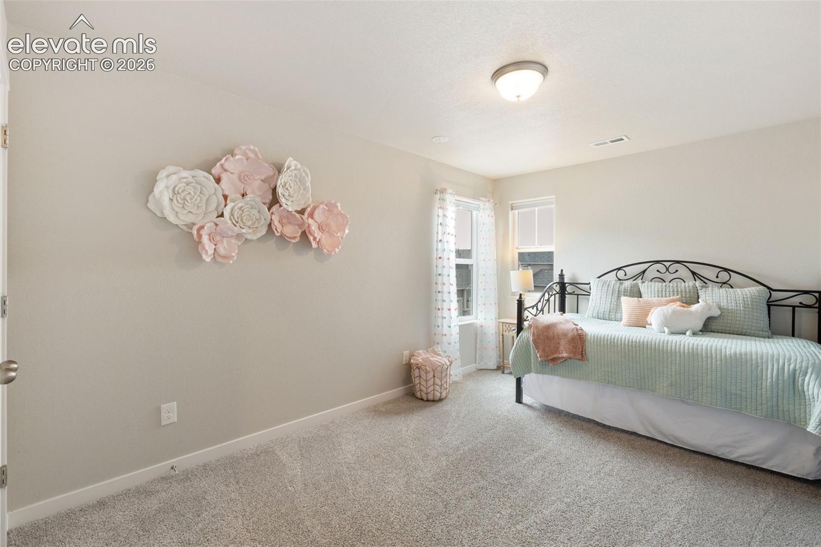 Carpeted interior room with neutral wall tones and a ceiling-mounted light fixture