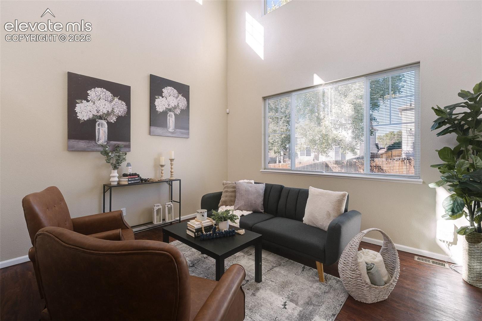 Double-height ceiling, large horizontal window, and wood-finish flooring