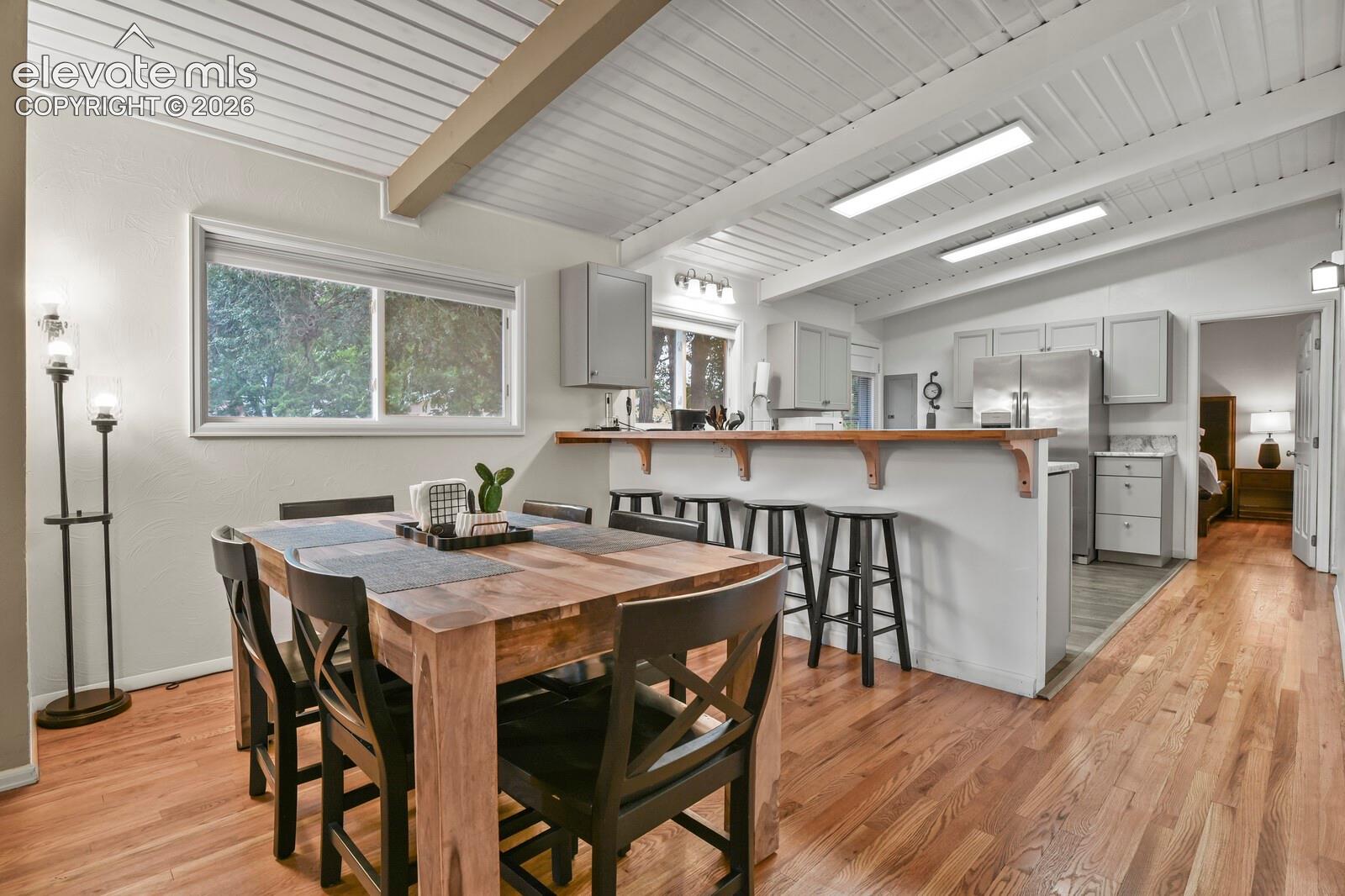 Dining area, breakfast bar, kitchen, door to primary bedroom.