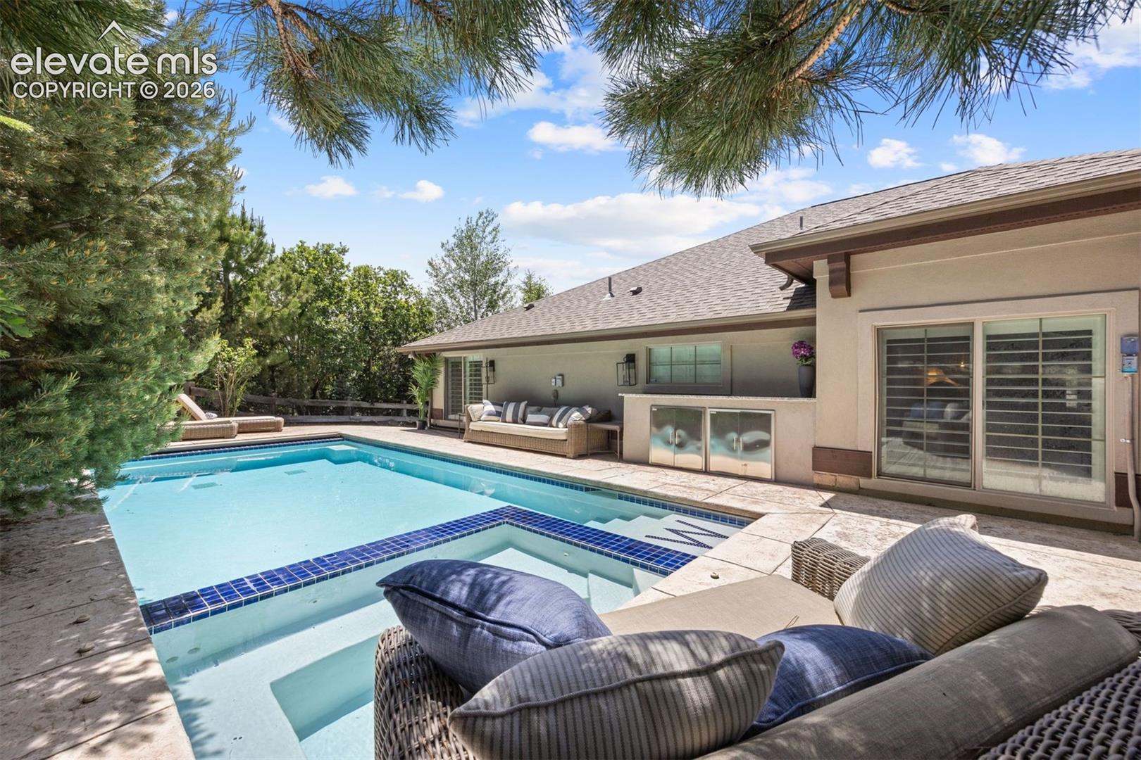 Outdoor swimming pool featuring a tiled spa and integrated steps