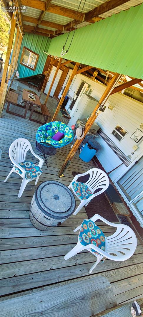 Covered outdoor deck with wood flooring and exposed wood beams