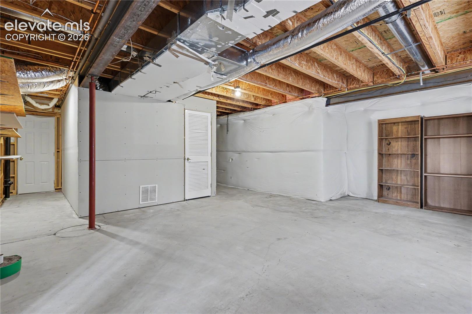 Unfinished lower level featuring concrete flooring and exposed ceiling joists